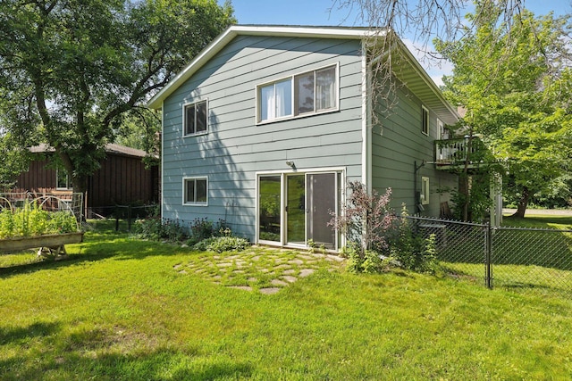 back of property featuring a yard and fence