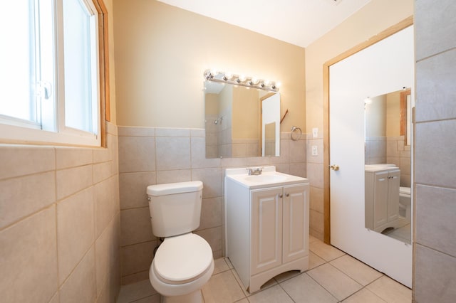 bathroom featuring vanity, tile walls, toilet, and tile patterned flooring