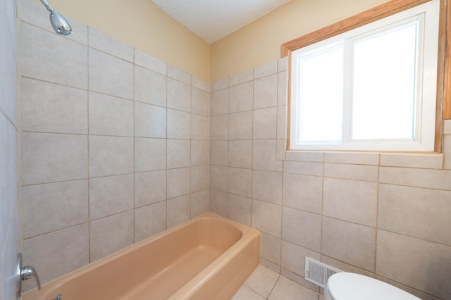 full bathroom featuring visible vents, a textured ceiling, tile patterned floors, toilet, and shower / bathtub combination