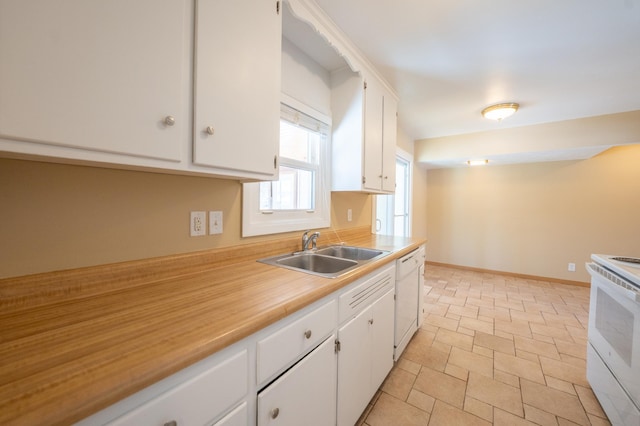 kitchen with a sink, white appliances, light countertops, and white cabinetry