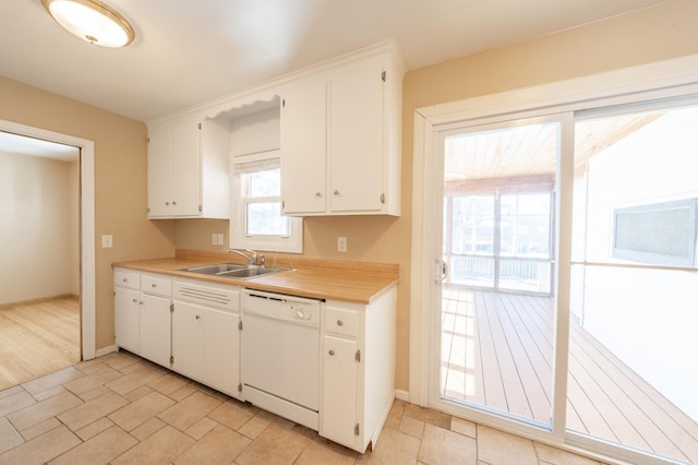 kitchen with dishwasher, white cabinetry, and a sink