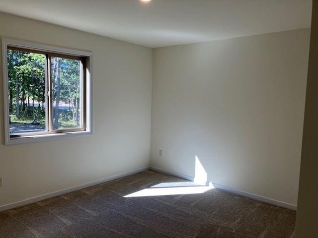 unfurnished room featuring carpet flooring and baseboards