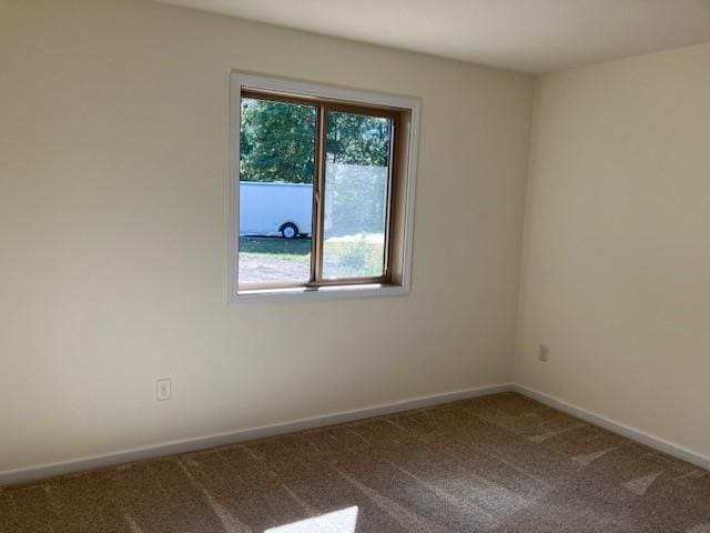 carpeted spare room with baseboards