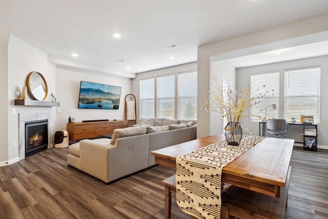 living room featuring a wealth of natural light, recessed lighting, a fireplace, and dark wood-style flooring