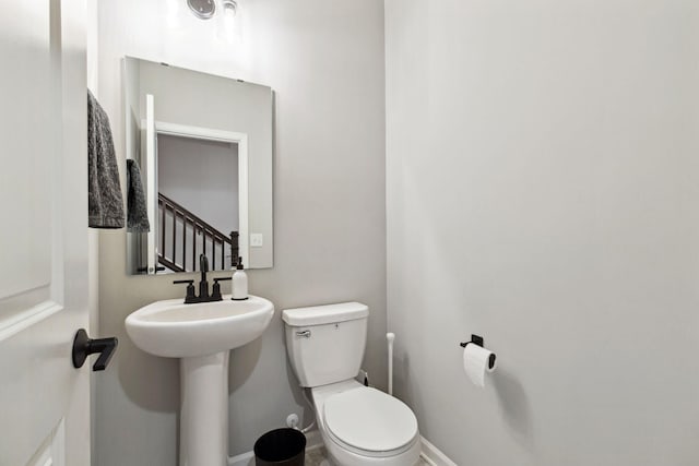 bathroom featuring baseboards and toilet