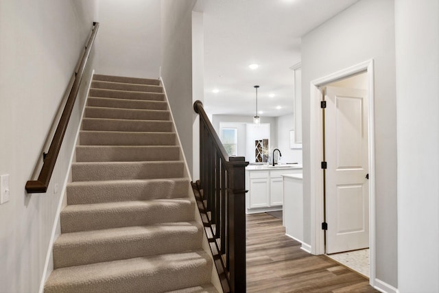 stairway with recessed lighting and wood finished floors