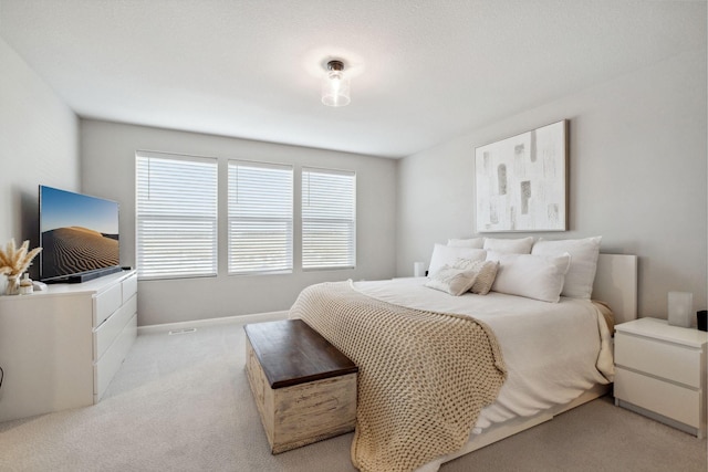 bedroom featuring baseboards and light carpet