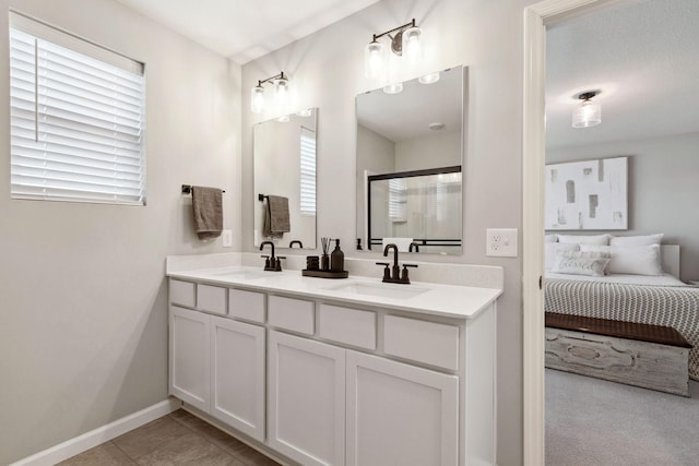 ensuite bathroom featuring tile patterned flooring, double vanity, ensuite bathroom, and a sink