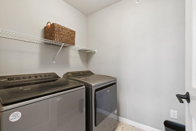 laundry area with laundry area, washer and dryer, and baseboards