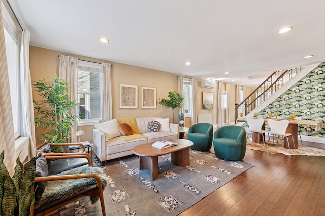 living room featuring a wall mounted air conditioner, stairway, recessed lighting, and hardwood / wood-style flooring