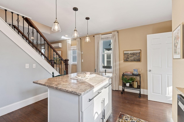 kitchen featuring an AC wall unit, a center island, dark wood-style floors, and pendant lighting