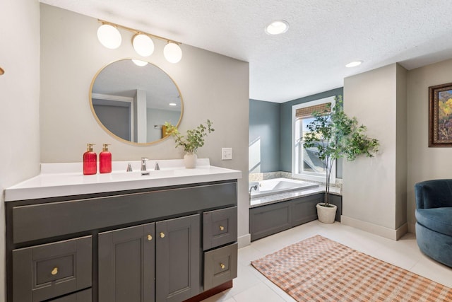 full bath with a garden tub, a textured ceiling, tile patterned flooring, baseboards, and vanity