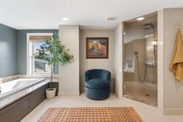 bathroom with visible vents, a garden tub, a walk in shower, a textured ceiling, and tile patterned flooring