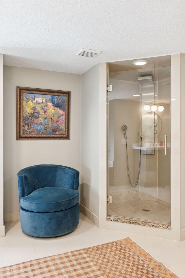 bathroom with tile patterned floors, visible vents, a textured ceiling, and a shower stall