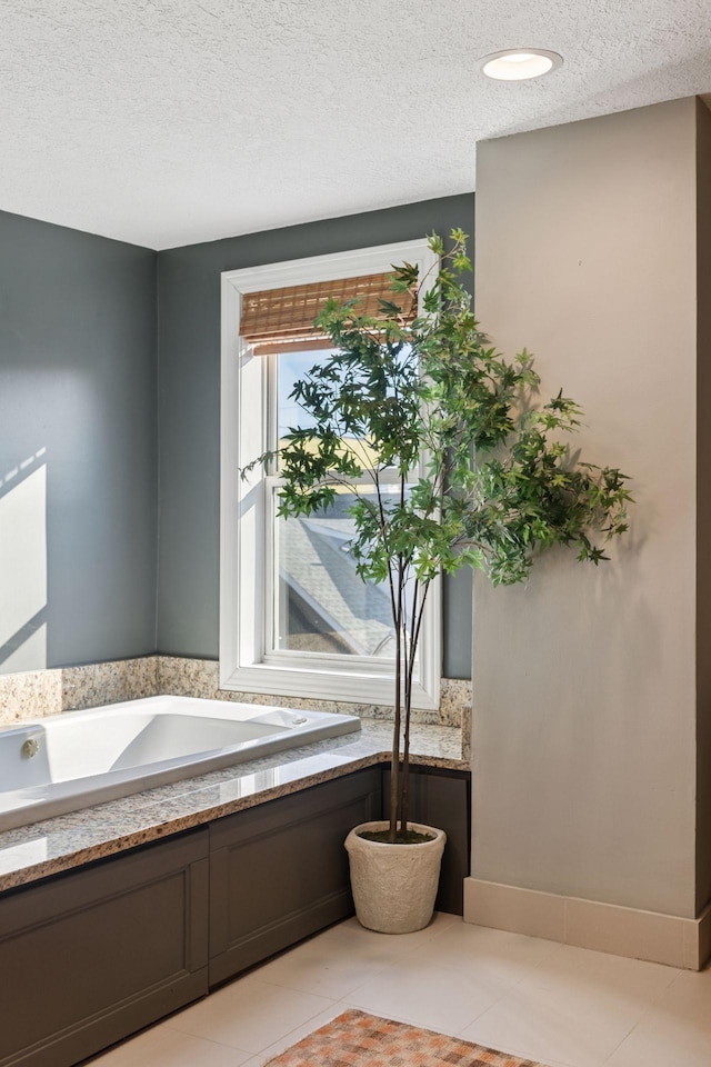 full bath with tile patterned floors, a textured ceiling, and a garden tub