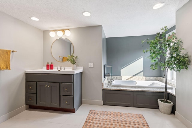 bathroom featuring vanity, a bath, baseboards, and a textured ceiling