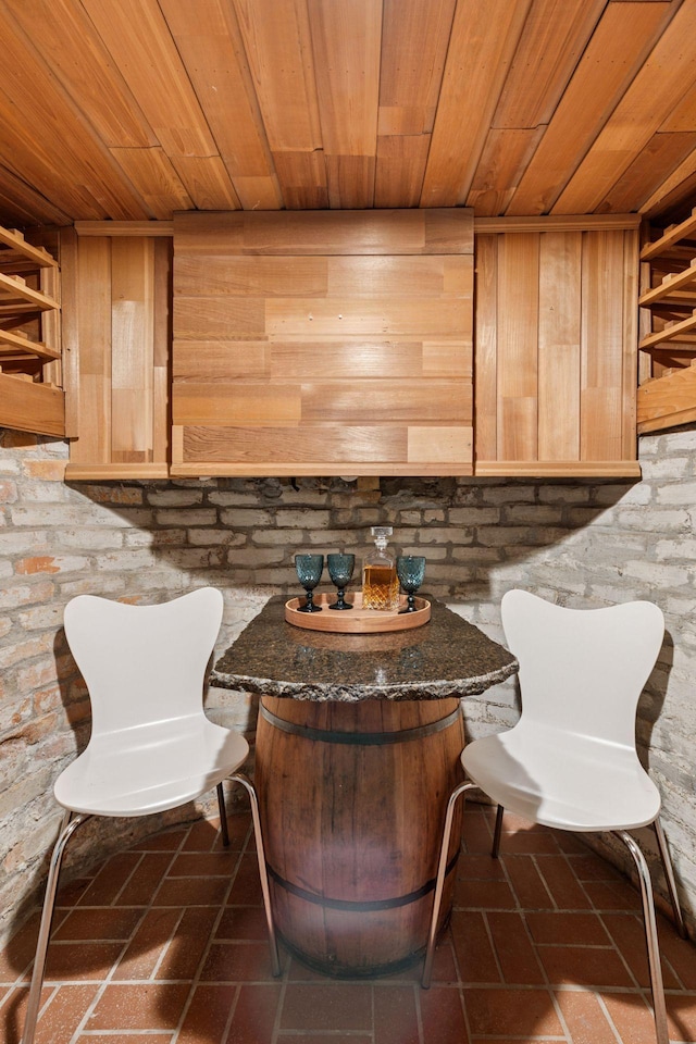 unfurnished room featuring wood ceiling and brick floor