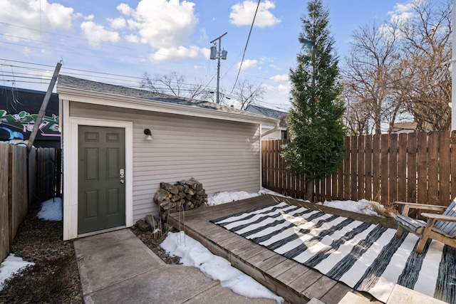 wooden deck with an outdoor structure and a fenced backyard