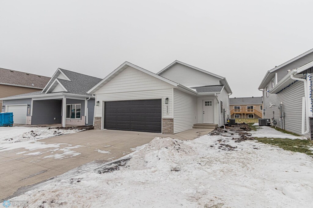 6322 82nd Ave S, Fargo, ND 58047 - view of front of house featuring central air condition unit, driveway, and an attached garage