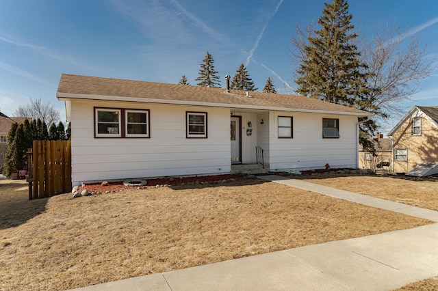 view of front of home with fence and roof with shingles