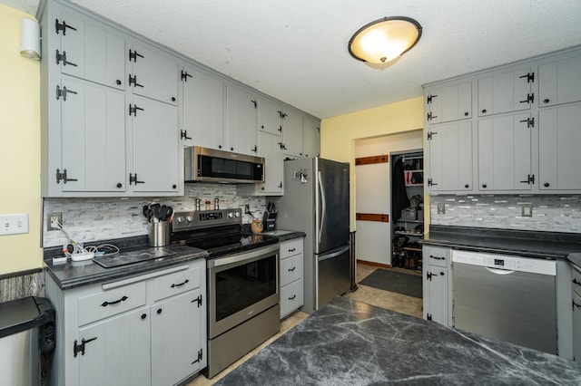 kitchen featuring backsplash, dark countertops, and appliances with stainless steel finishes