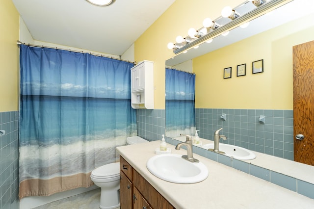 bathroom with a wainscoted wall, toilet, tile walls, and vanity