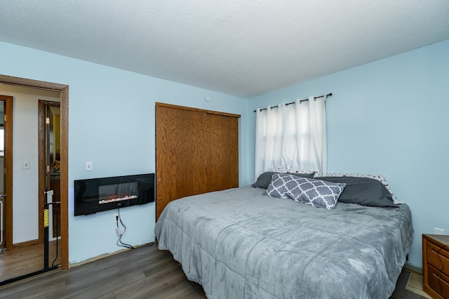 bedroom featuring a closet, a textured ceiling, and wood finished floors