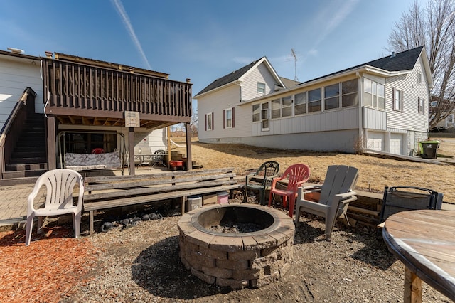 back of house with a wooden deck, stairs, and an outdoor fire pit