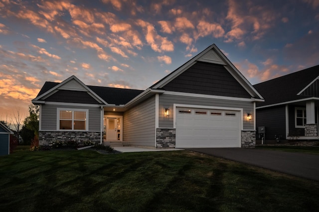 craftsman-style house with stone siding, a garage, concrete driveway, and a yard