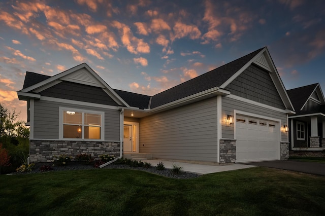 craftsman inspired home featuring a garage, stone siding, a lawn, and driveway