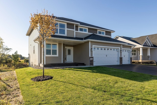 view of front of property featuring a front lawn, an attached garage, and aphalt driveway