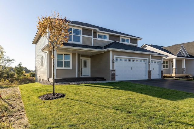 view of front of home featuring a front yard, a garage, and aphalt driveway