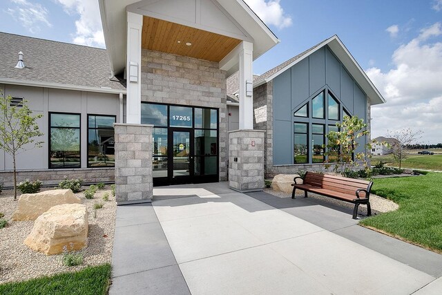 view of exterior entry featuring stone siding and board and batten siding