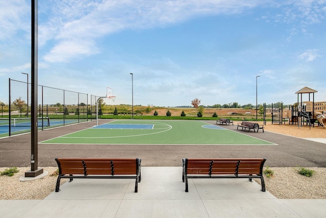 view of basketball court with community basketball court, fence, and playground community