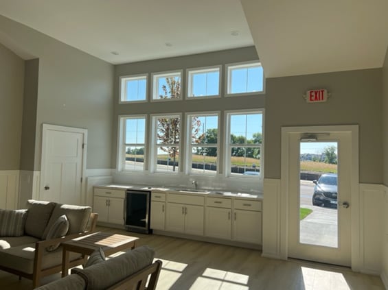 interior space featuring beverage cooler, wainscoting, and light wood-style flooring