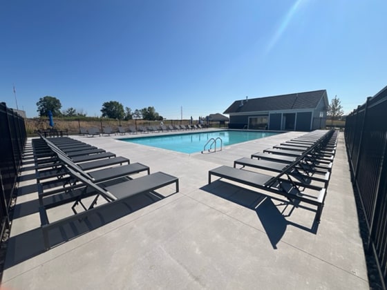 community pool with a patio area and fence