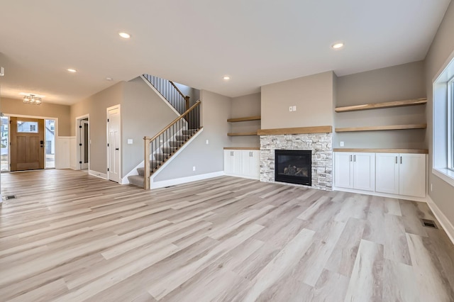 unfurnished living room featuring stairway, recessed lighting, and light wood finished floors