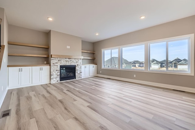 unfurnished living room featuring visible vents, baseboards, recessed lighting, a fireplace, and light wood-style floors