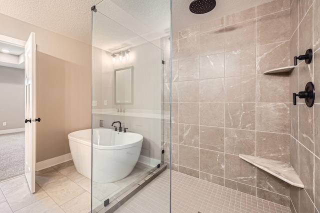 bathroom with tile patterned floors, a textured ceiling, baseboards, a soaking tub, and walk in shower