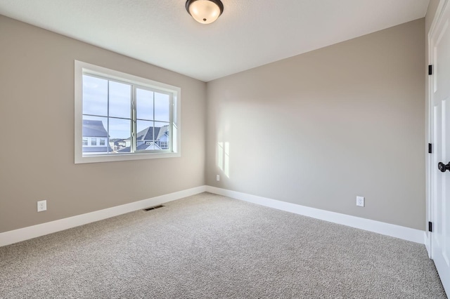 carpeted empty room with visible vents and baseboards