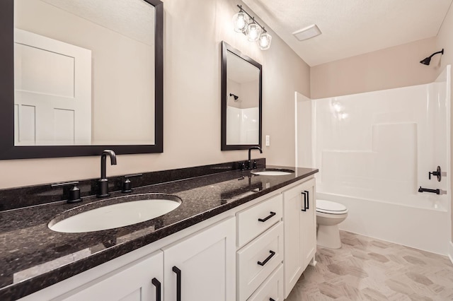 full bathroom with double vanity, toilet, washtub / shower combination, and a sink