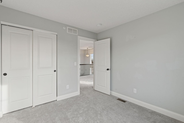 unfurnished bedroom featuring visible vents, baseboards, and carpet