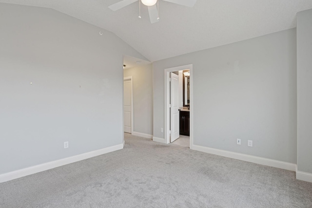 spare room with light carpet, a ceiling fan, baseboards, and vaulted ceiling