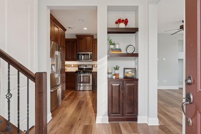 kitchen with appliances with stainless steel finishes, a ceiling fan, light wood-style floors, and open shelves