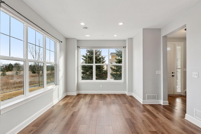 empty room with visible vents, recessed lighting, baseboards, and wood finished floors