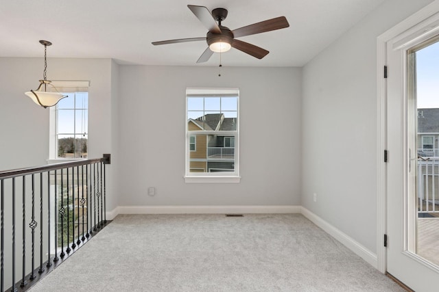 unfurnished room featuring plenty of natural light, baseboards, and carpet floors