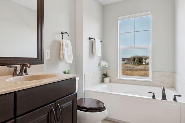 bathroom featuring toilet, a bath, and vanity