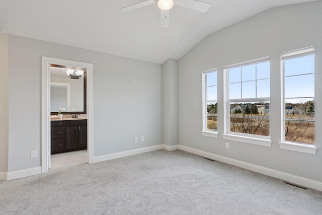 unfurnished bedroom with vaulted ceiling, baseboards, visible vents, and light carpet