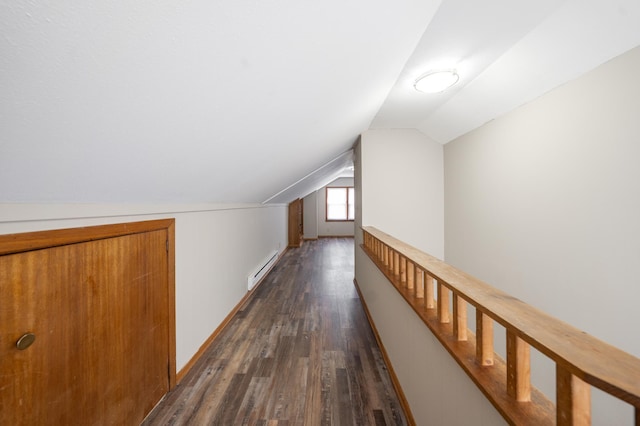 hallway with a baseboard heating unit, dark wood-type flooring, and vaulted ceiling