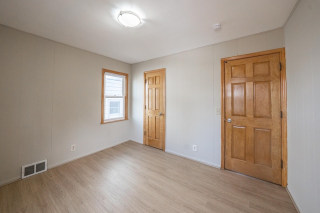 unfurnished bedroom with visible vents, baseboards, and light wood-style floors